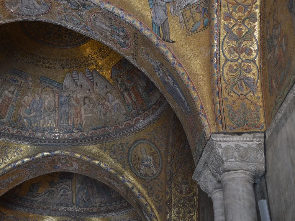 Gold mosaic vaults and arches inside St Mark's Basilica seen from below